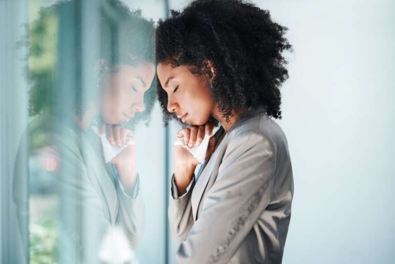 Woman leaning against glass with reflection